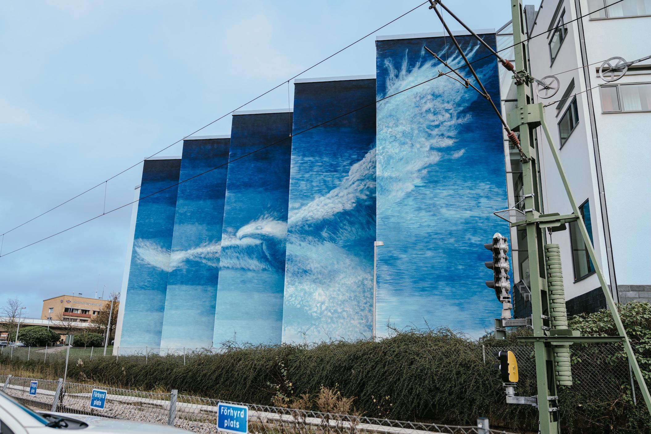 En fasad med en blå muralmålning på.